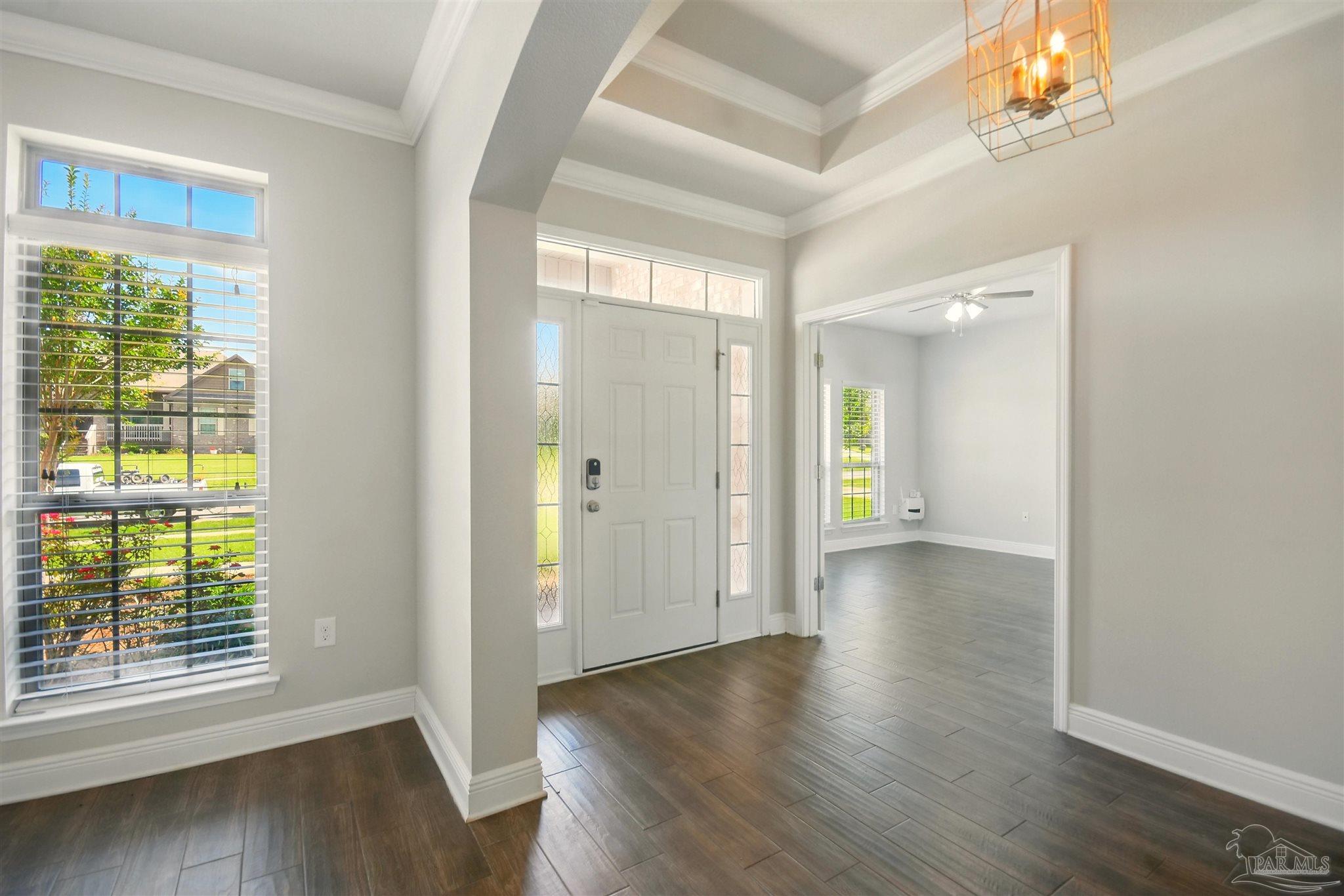a view of a hallway with wooden floor and a window