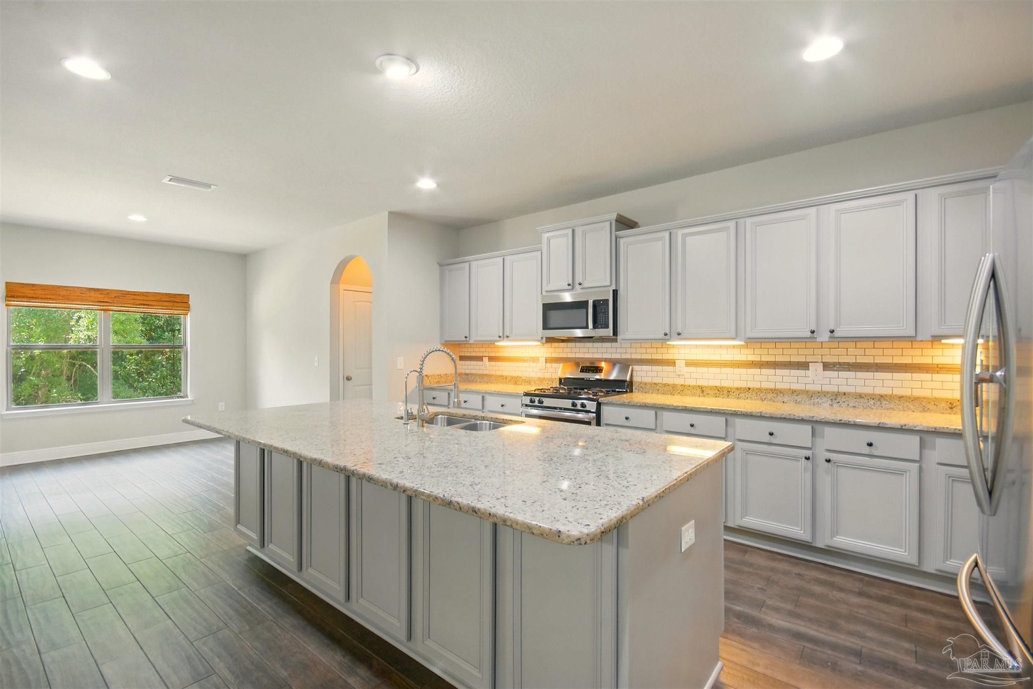 2701 Tulip Hill Road Pace, FL 32571 - Photo 12 of 42 a kitchen with stainless steel appliances granite countertop a sink a stove and cabinets