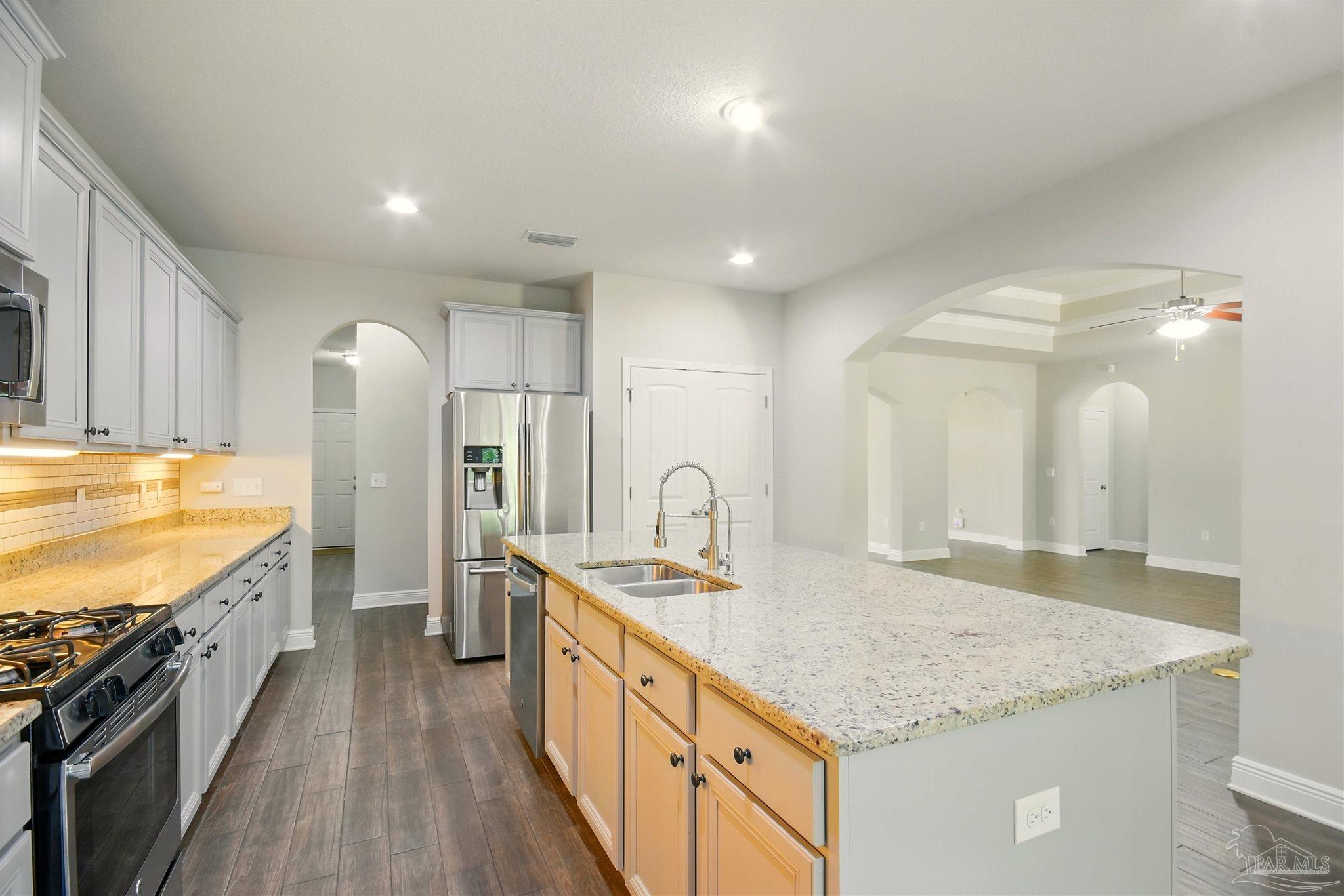 2701 Tulip Hill Road Pace, FL 32571 - Photo 14 of 42 a kitchen with stainless steel appliances granite countertop a sink stove and refrigerator