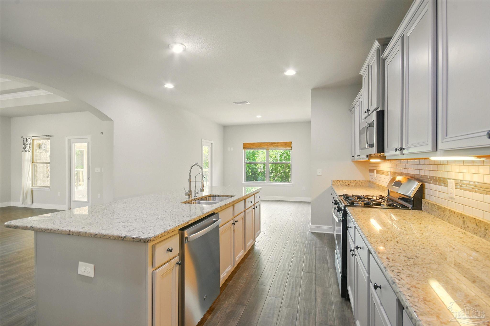 2701 Tulip Hill Road Pace, FL 32571 - Photo 15 of 42 a kitchen with a sink stove and cabinets