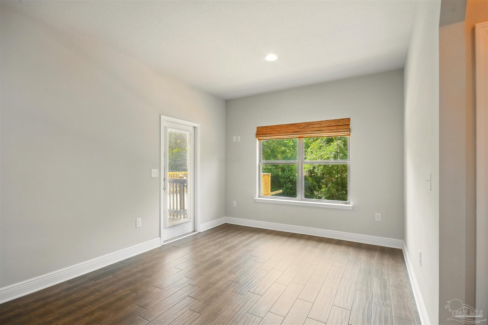 2701 Tulip Hill Road Pace, FL 32571 - Photo 17 of 42 an empty room with wooden floor and windows