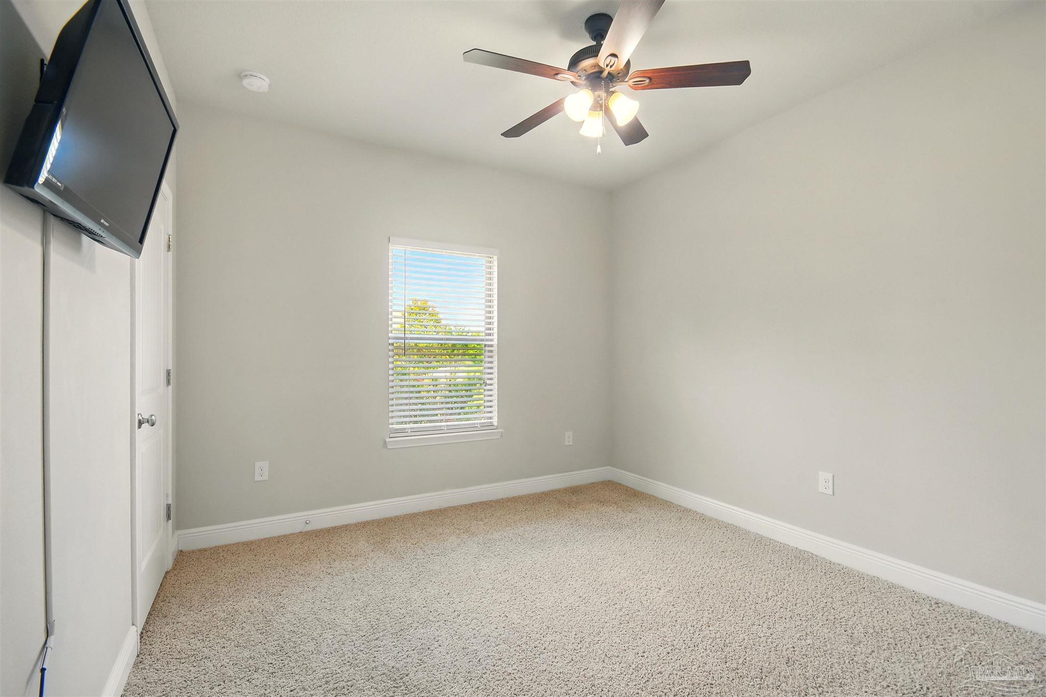 2701 Tulip Hill Road Pace, FL 32571 - Photo 25 of 42 an empty room with a window and a ceiling fan