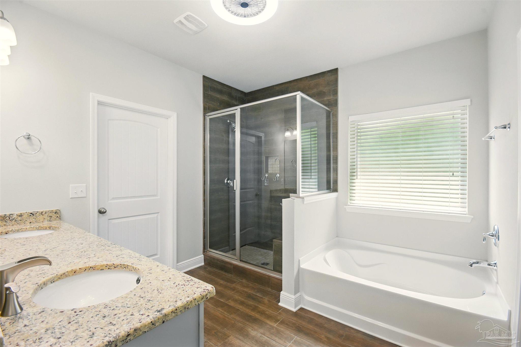 2701 Tulip Hill Road Pace, FL 32571 - Photo 30 of 42 a bathroom with a granite countertop tub sink and mirror