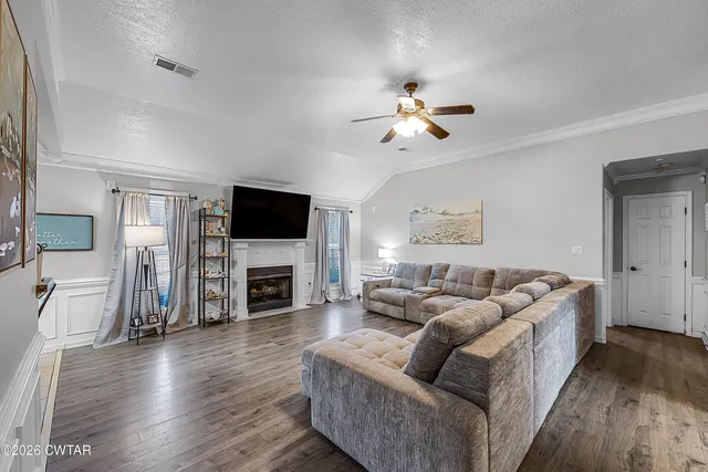 a living room with fireplace furniture and a wooden floor