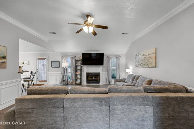 a living room with furniture a fireplace and a flat screen tv