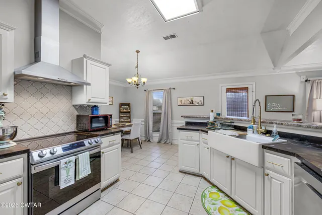 a kitchen with stainless steel appliances a stove a sink and a refrigerator