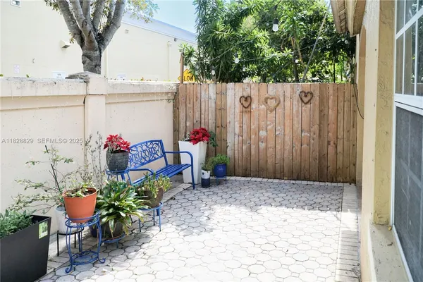 a view of a backyard with potted plants and large tree