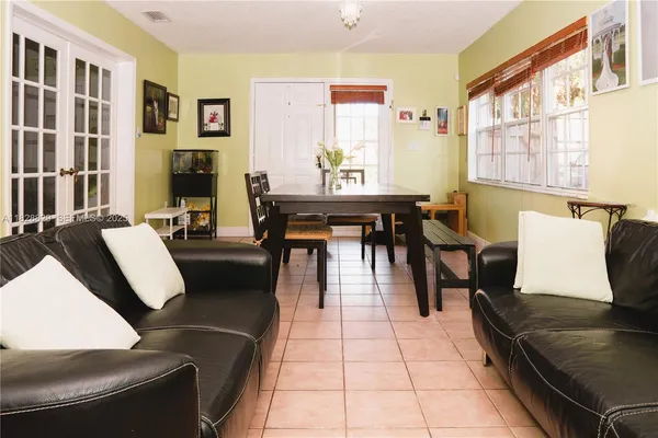 a living room with furniture two windows and a dining table