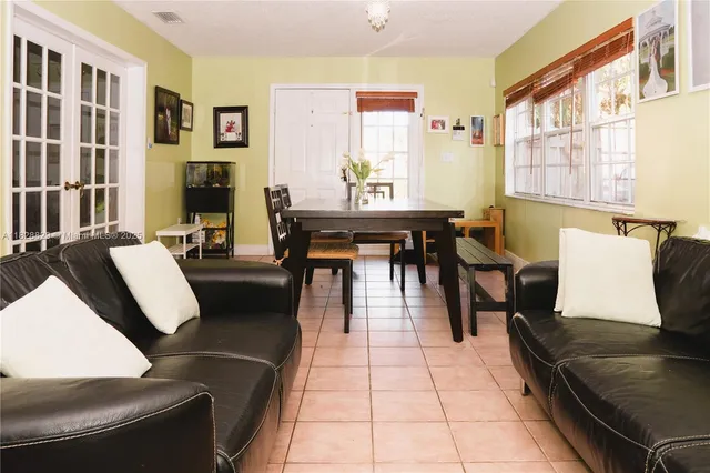 a living room with furniture two windows and a dining table