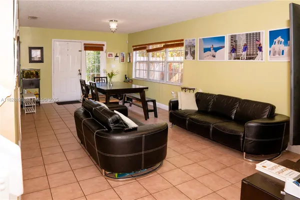 a living room with couches and a dining table with kitchen view