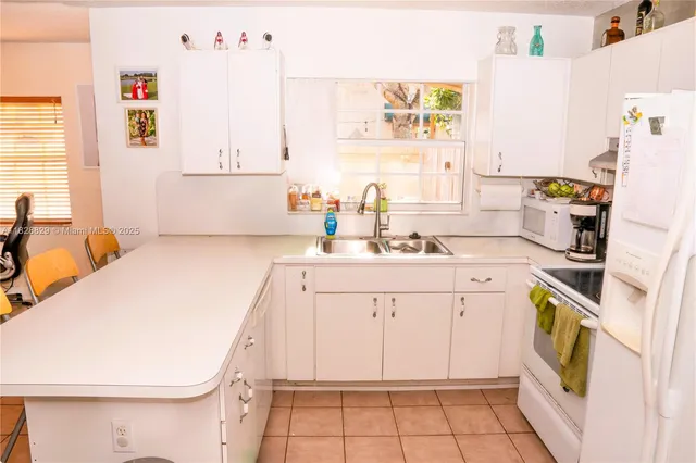a utility room with cabinets washer and dryer