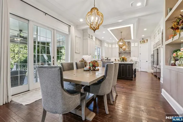 a view of a dining room with furniture a chandelier and wooden floor