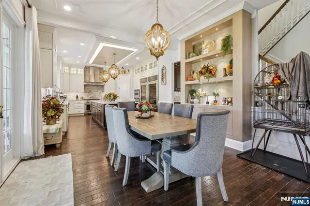 a view of a dining room with furniture a chandelier and wooden floor