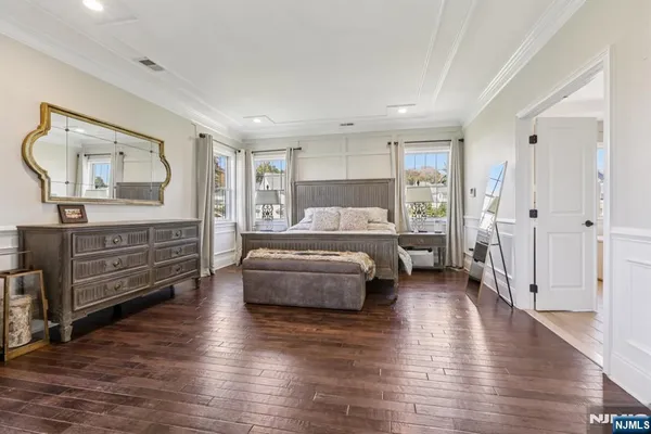 a spacious bedroom with a bed and wooden floor