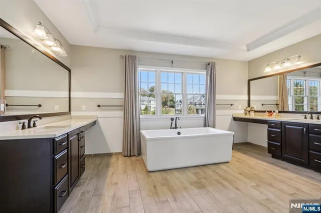 a living room with stainless steel appliances granite countertop a sink dishwasher and a stove with wooden floor