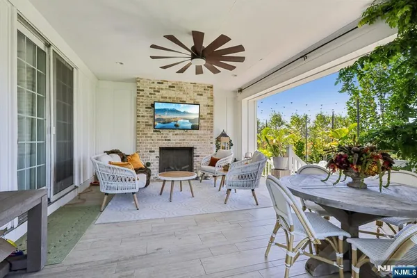 a view of a patio with couches plants and large tree