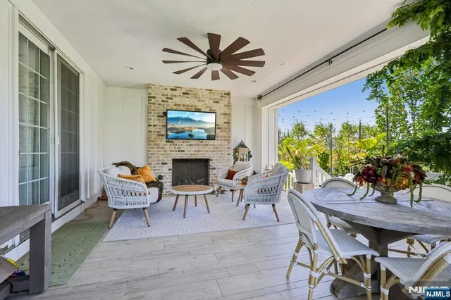 a view of a patio with couches plants and large tree