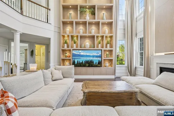 a living room with furniture kitchen view and a large window