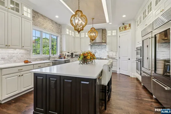 a kitchen with stainless steel appliances granite countertop a sink a stove and a wooden floors