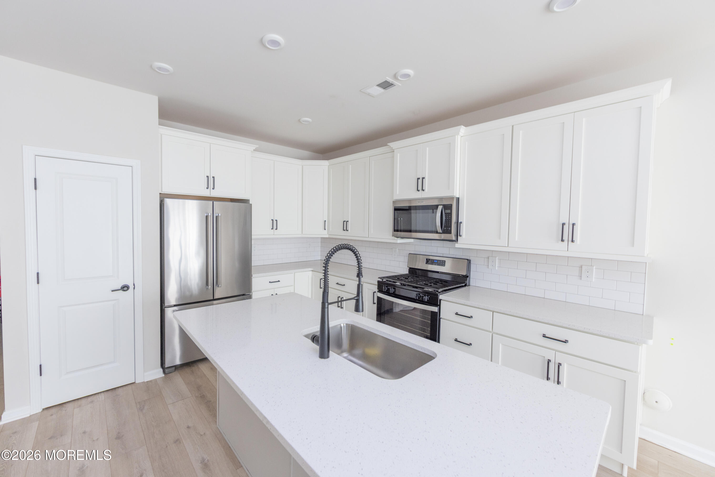 16 Chapel Lane Neptune, NJ 07753 - Photo 7 of 27 a kitchen with stainless steel appliances granite countertop a refrigerator a stove a sink and white cabinets