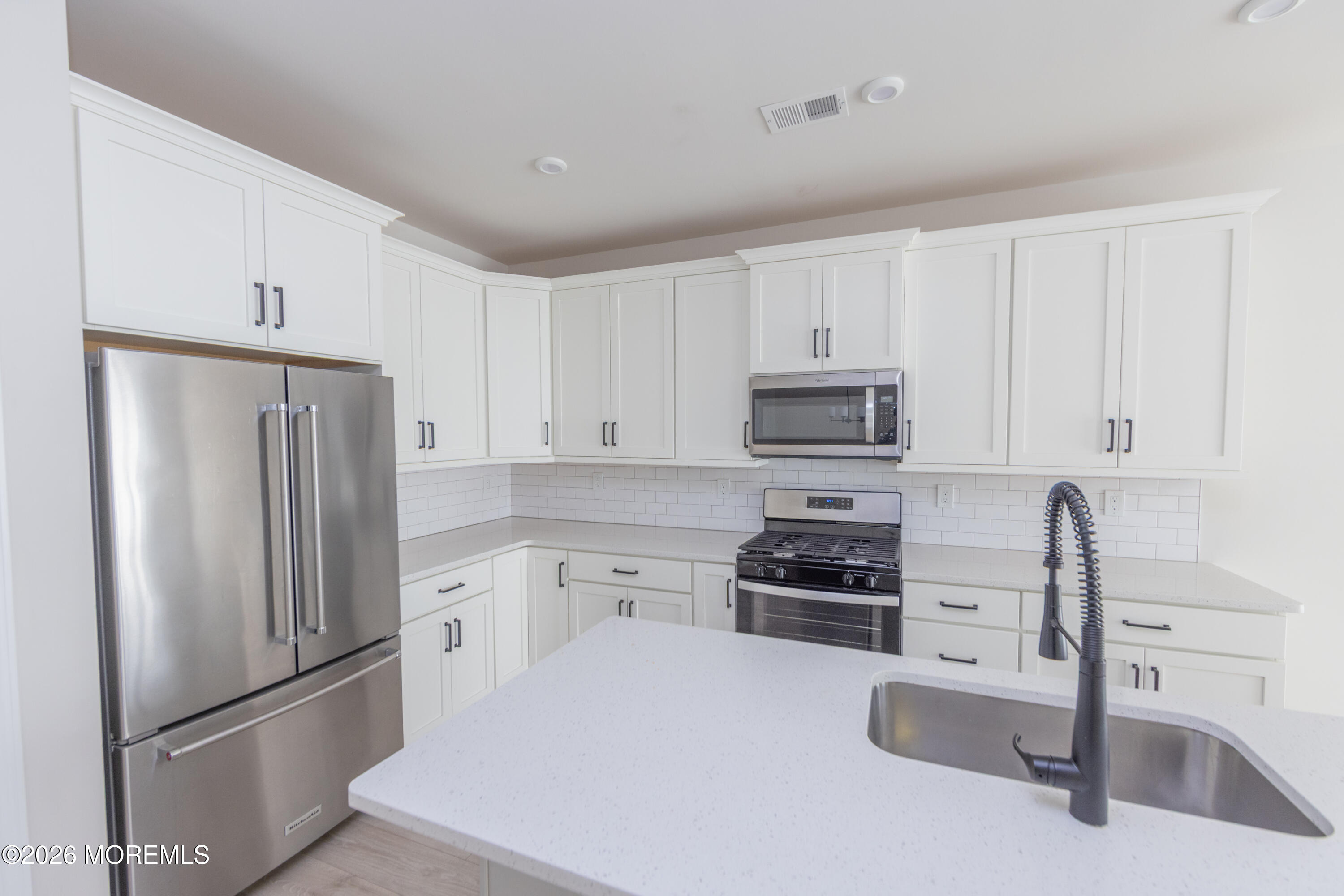 16 Chapel Lane Neptune, NJ 07753 - Photo 9 of 27 a kitchen with refrigerator a stove a sink and white cabinets