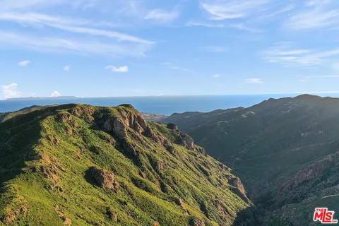 a view of a large building with mountains in the background