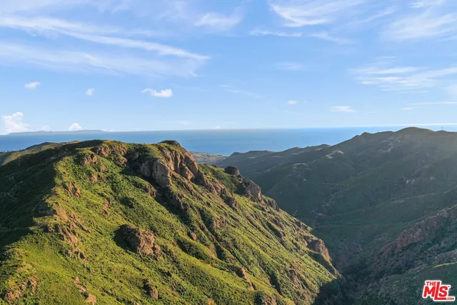a view of a large building with mountains in the background