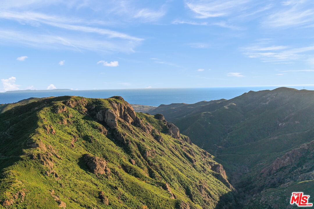 1100 Kanan Dume Road Malibu, CA 90265 - Photo 2 of 13 a view of a large building with mountains in the background
