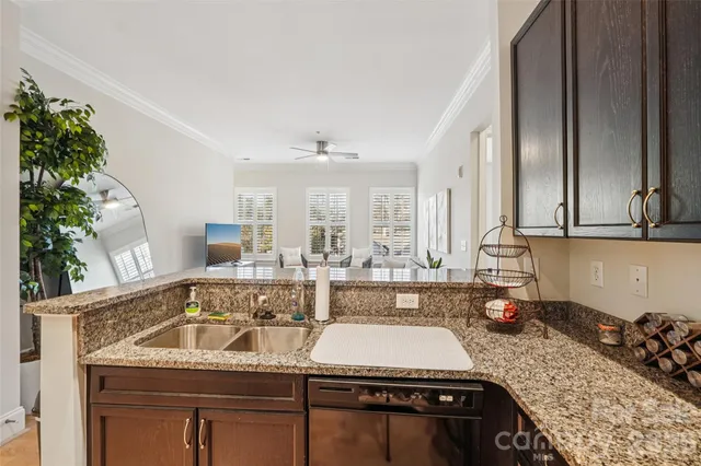a kitchen with granite countertop a refrigerator and a sink