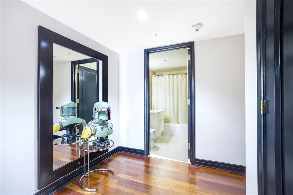 3 Avery Street, Unit 804 Boston, MA 02111 - Photo 17 of 21 a view of a hallway to a livingroom with furniture and wooden floor