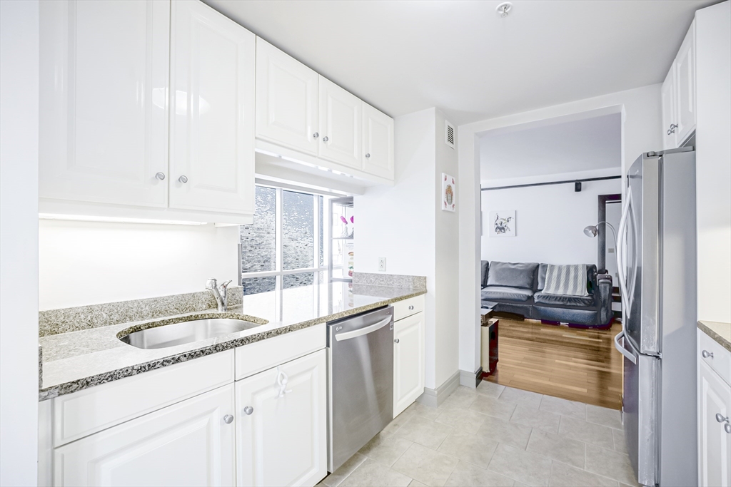 3 Avery Street, Unit 804 Boston, MA 02111 - Photo 7 of 21 a kitchen with granite countertop a sink stove and refrigerator