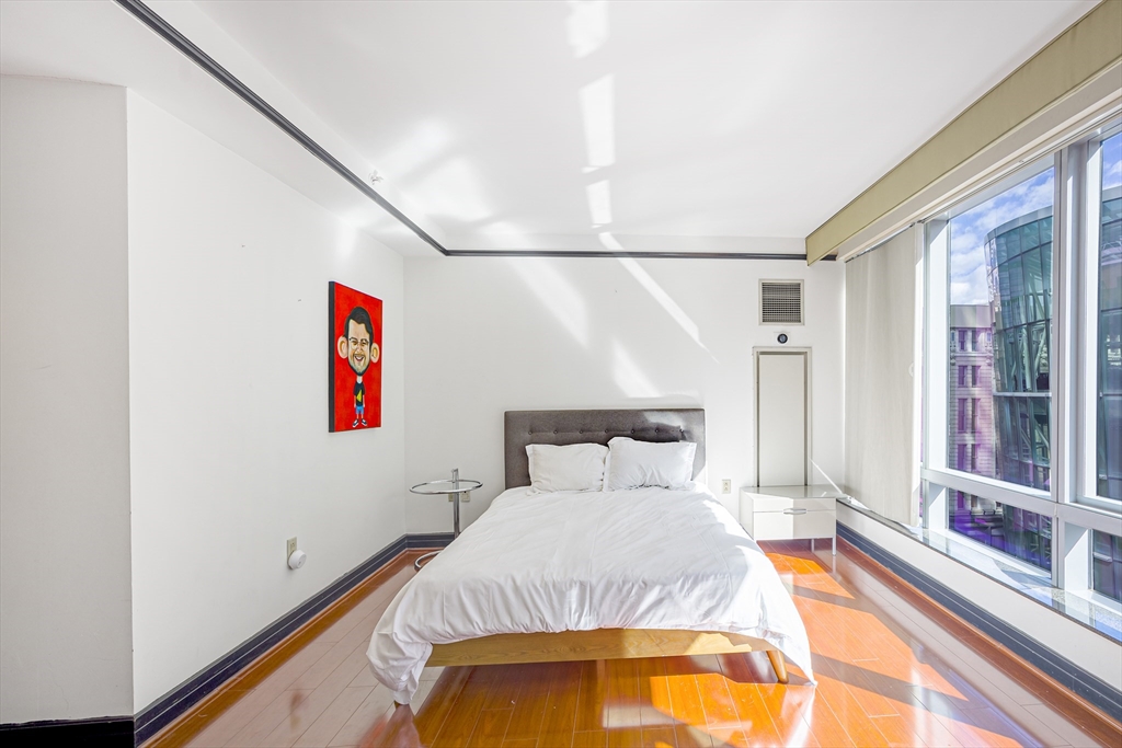 3 Avery Street, Unit 804 Boston, MA 02111 - Photo 10 of 21 a bedroom with a bed and a potted plant on the wall