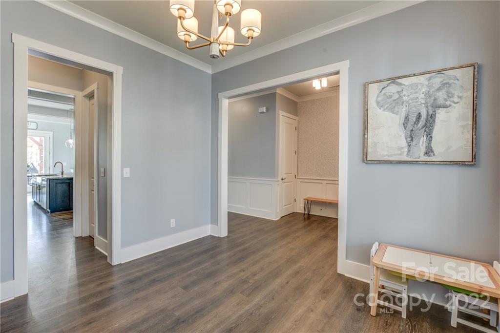 1106 Currituck Way York, SC 29745 - Photo 15 of 45 an empty room with wooden floor and a chandelier