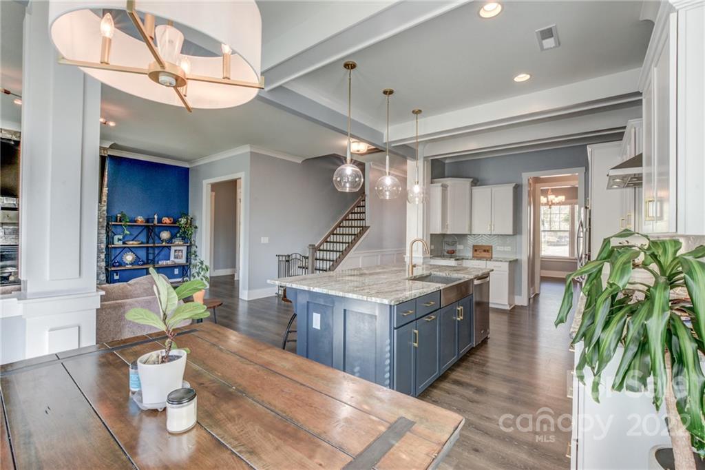 1106 Currituck Way York, SC 29745 - Photo 21 of 45 a kitchen with a stove a refrigerator and a dining table with wooden floor