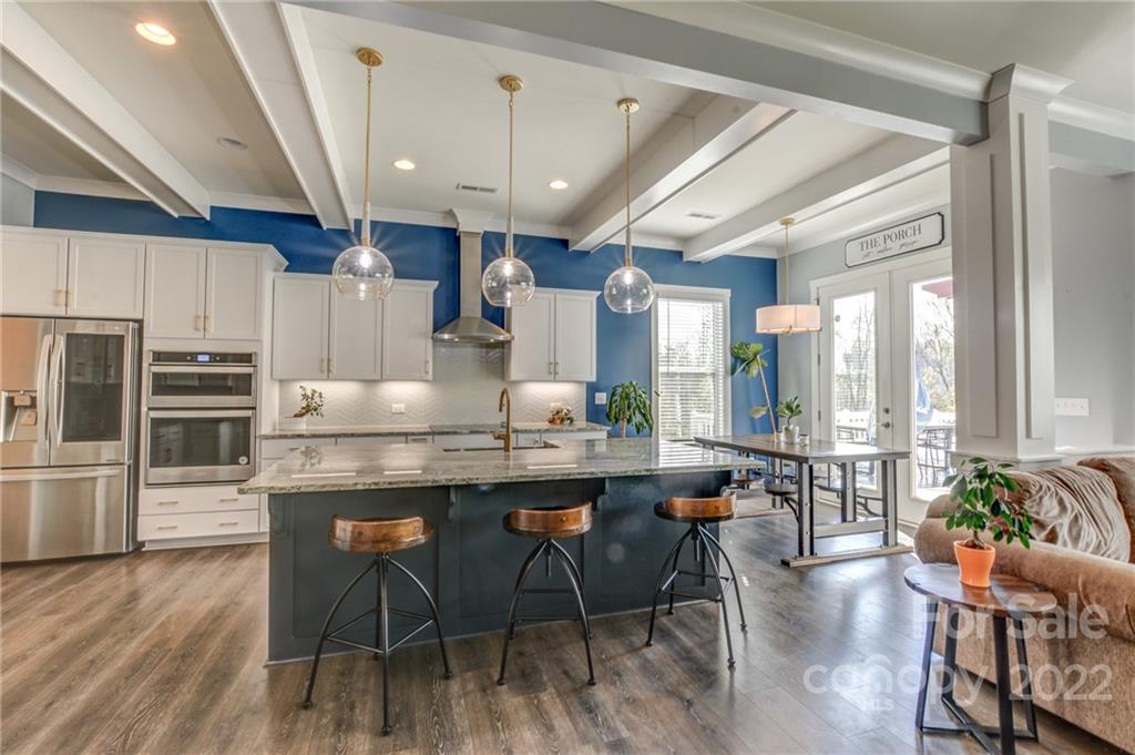 1106 Currituck Way York, SC 29745 - Photo 7 of 45 a kitchen with stainless steel appliances kitchen island granite countertop a table chairs cabinets and wooden floor