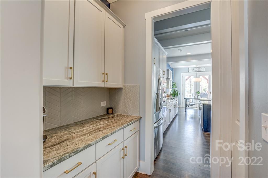 1106 Currituck Way York, SC 29745 - Photo 9 of 45 a hallway with granite countertop white cabinets and wooden floor
