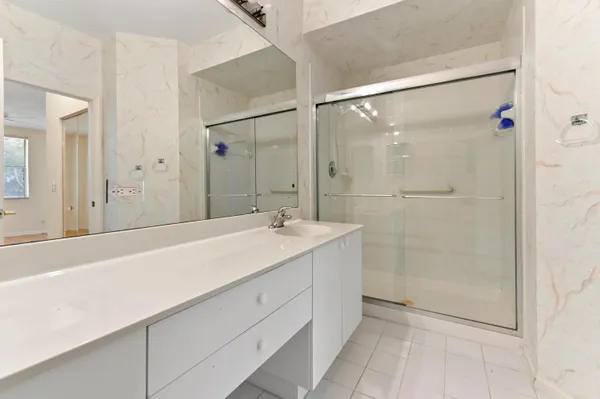 a bathroom with a shower sink vanity and mirror