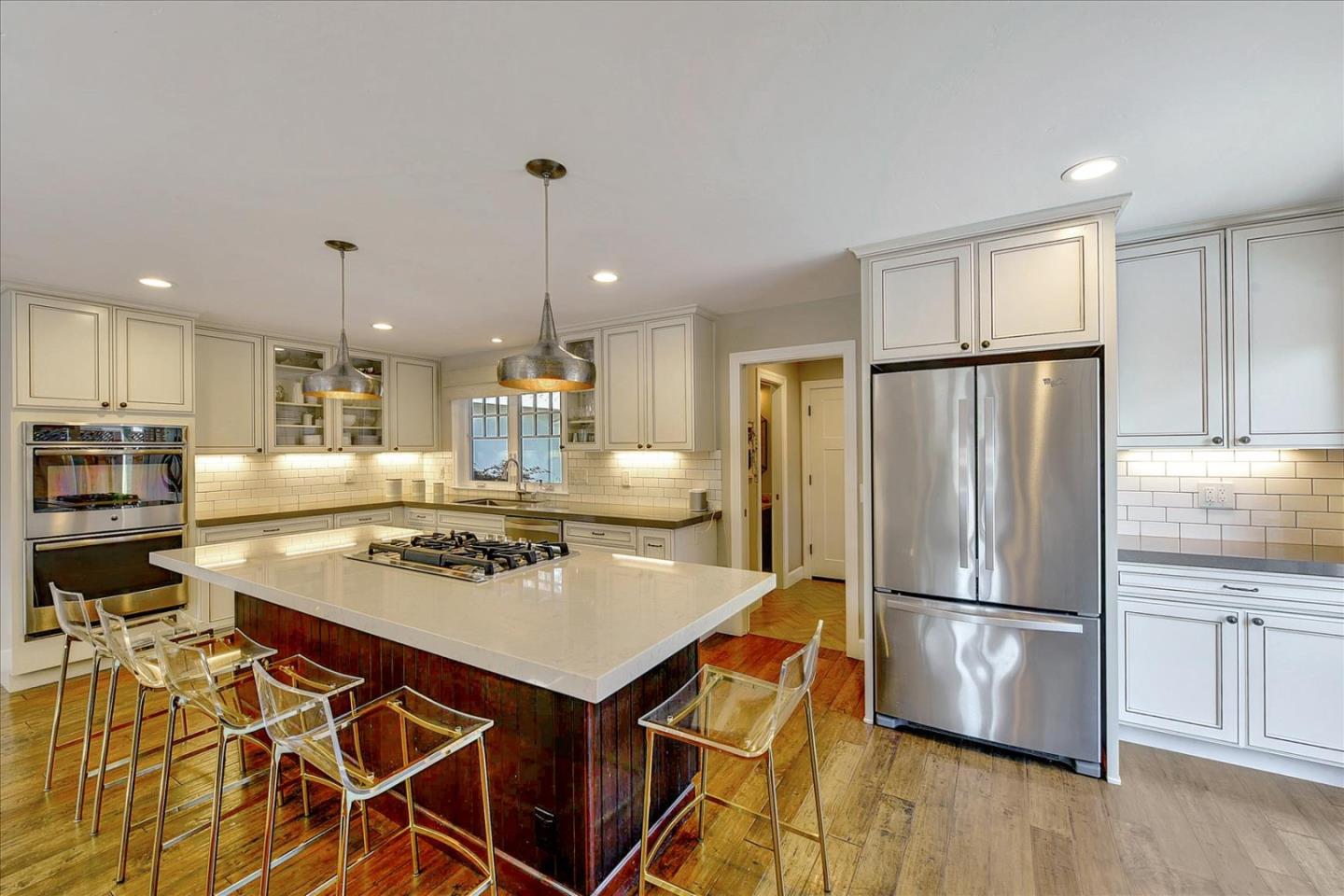 2215 Constitution Drive San Jose, CA 95124 - Photo 7 of 36 a kitchen with stainless steel appliances granite countertop a refrigerator a stove a sink dishwasher a dining table and chairs with wooden floor