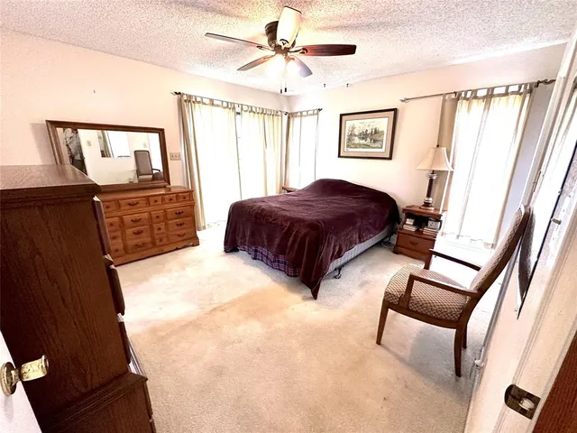 a bedroom with a bed a dresser and next to a window