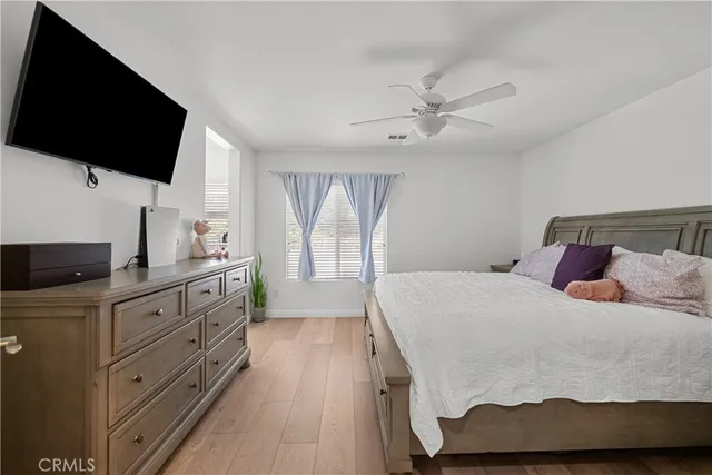 a spacious bedroom with a bed and a flat screen tv