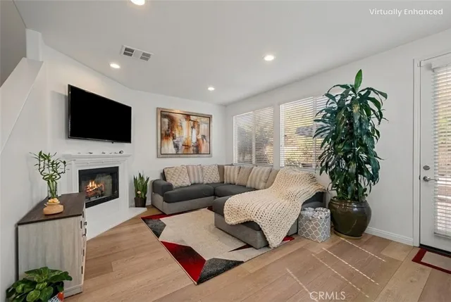 a living room with furniture a flat screen tv and a fireplace