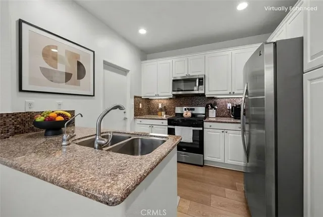 a kitchen with stainless steel appliances granite countertop a refrigerator sink and microwave