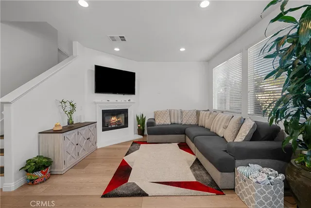 a living room with furniture a flat screen tv and a fireplace