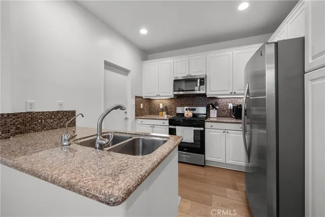 a kitchen with kitchen island a sink a refrigerator and cabinets