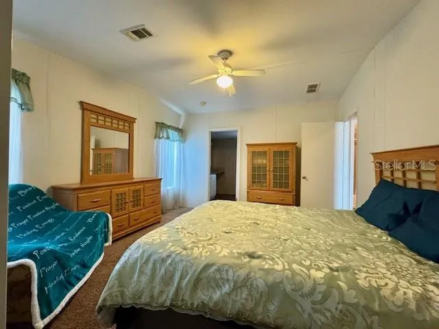 a bedroom with a bed and dresser with mirror