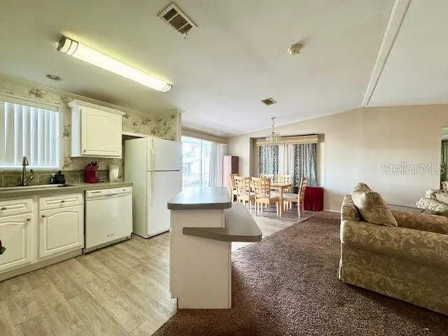 a large white kitchen with lots of counter space and furniture