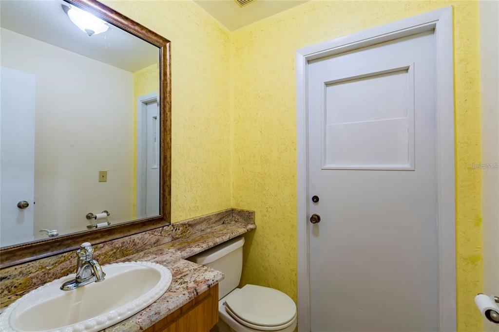 1647 Hobbit Road Dunedin, FL 34698 - Photo 18 of 36 a bathroom with a granite countertop sink and a mirror