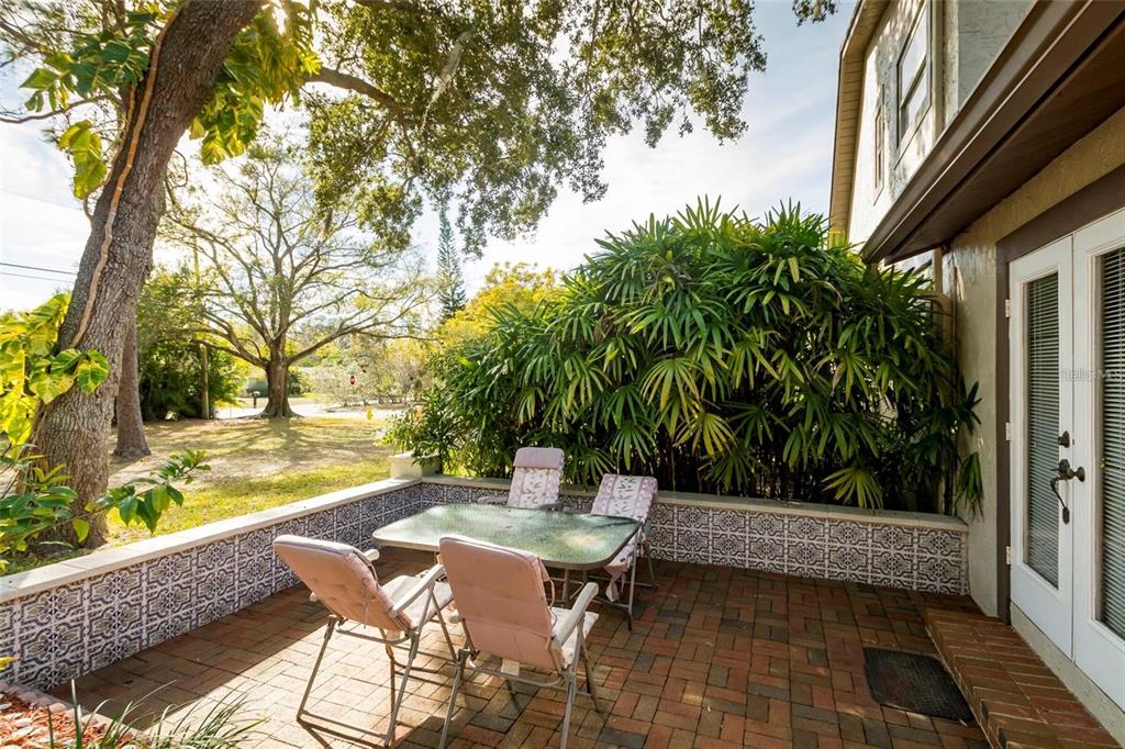 1647 Hobbit Road Dunedin, FL 34698 - Photo 8 of 36 a view of a patio with table and chairs and floor to ceiling window