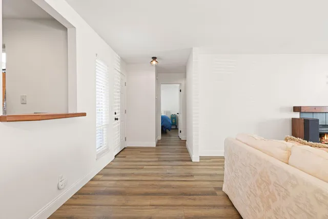 a view of a hallway with wooden floor and staircase