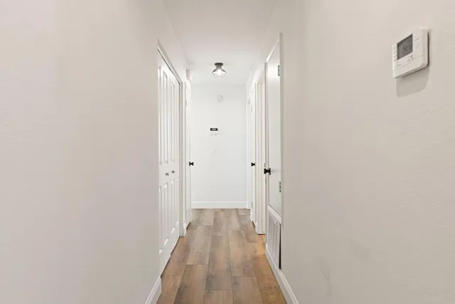 a view of a hallway with wooden floor
